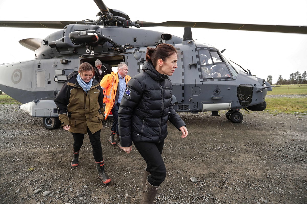 New Zealands Prime Minister Jacinda Ardern (C) alights from an army helicopter on June 1, 2021 as she inspects the flood damage after heavy rains washed away bridges and cut roads in the Canterbury region. 