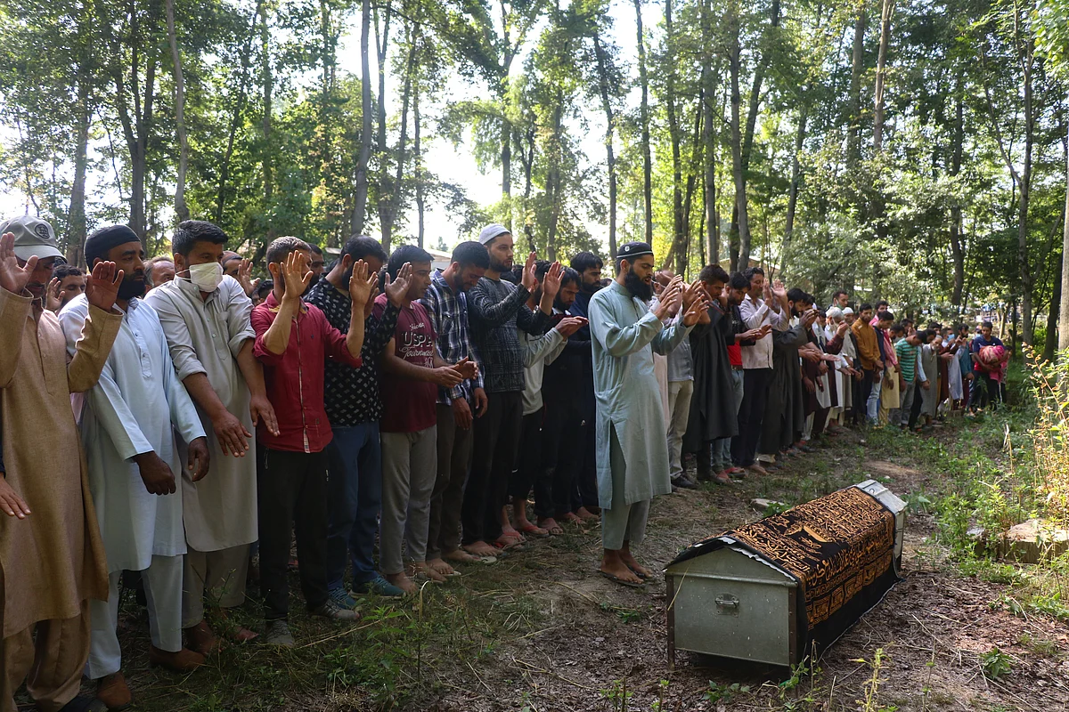 Villagers pray during the funeral of Fayaz Ahmed, former SPO of Jammu & Kashmir Police, who was killed along with his daughter, and wife by suspected militants, in Hariparigam village of Pulwama district of Kashmir on June 27, 2021.