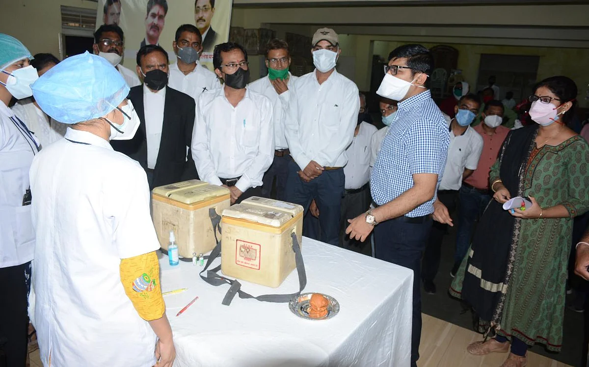 Municipal commissioner Kshitij Singal interacts with the staff of vaccination centre at District Court in Ujjain on Wednesday. FP PHOTO