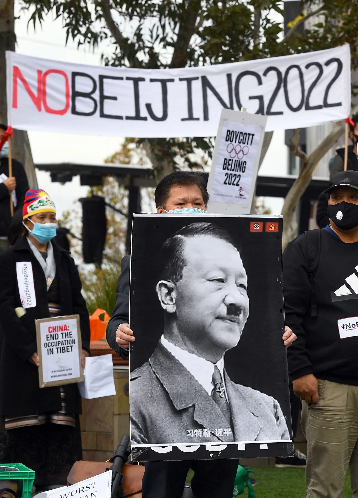 Activists including members of the local Hong Kong, Tibetan and Uyghur communities hold up banners and placards in Melbourne on June 23, 2021, calling on the Australian government to boycott the 2022 Beijing Winter Olympics over China's human rights record.