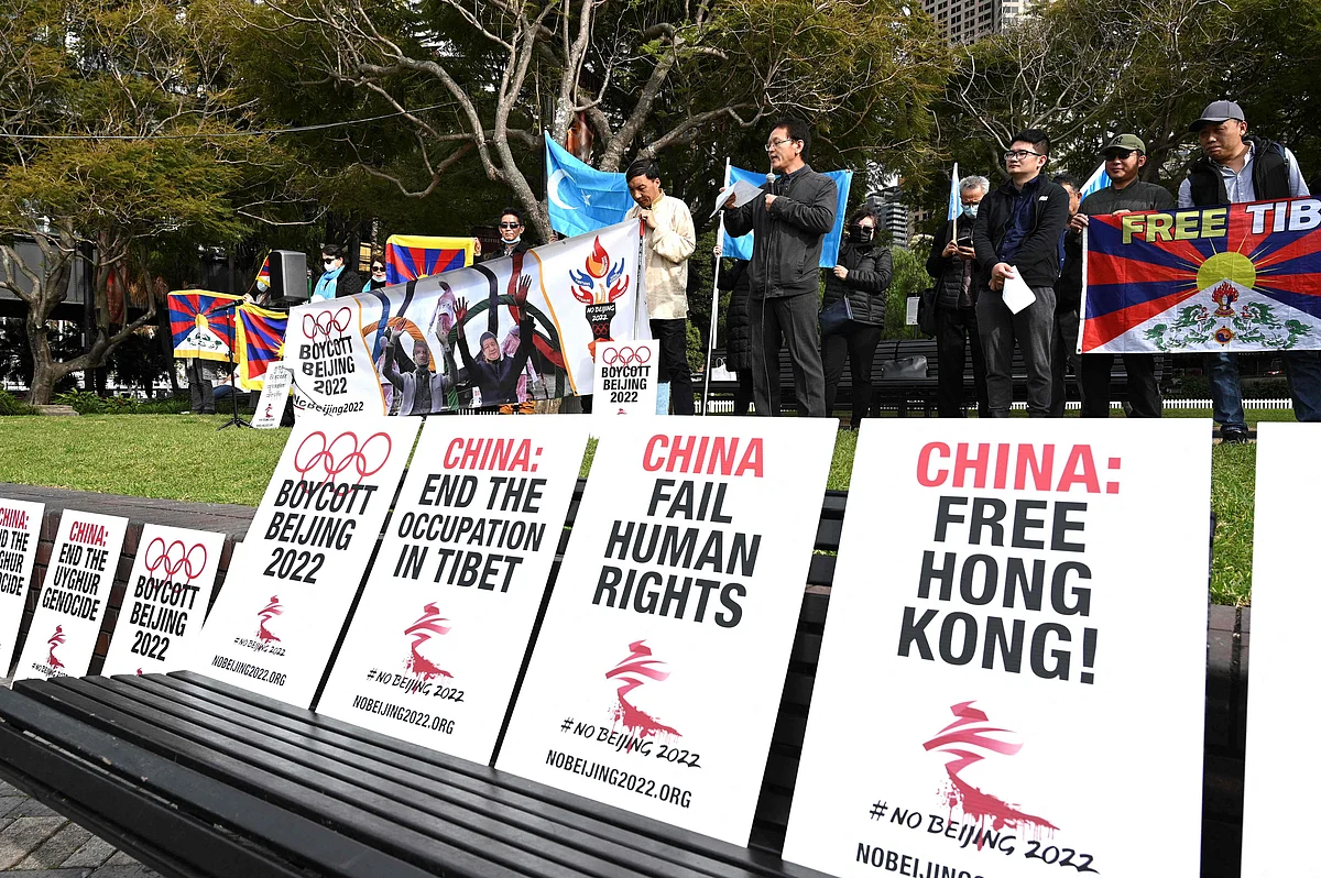 Protesters hold up placards and banners as they attend a demonstration in Sydney on June 23, 2021 to call on the Australian government to boycott the 2022 Beijing Winter Olympics over Chinas human rights record.