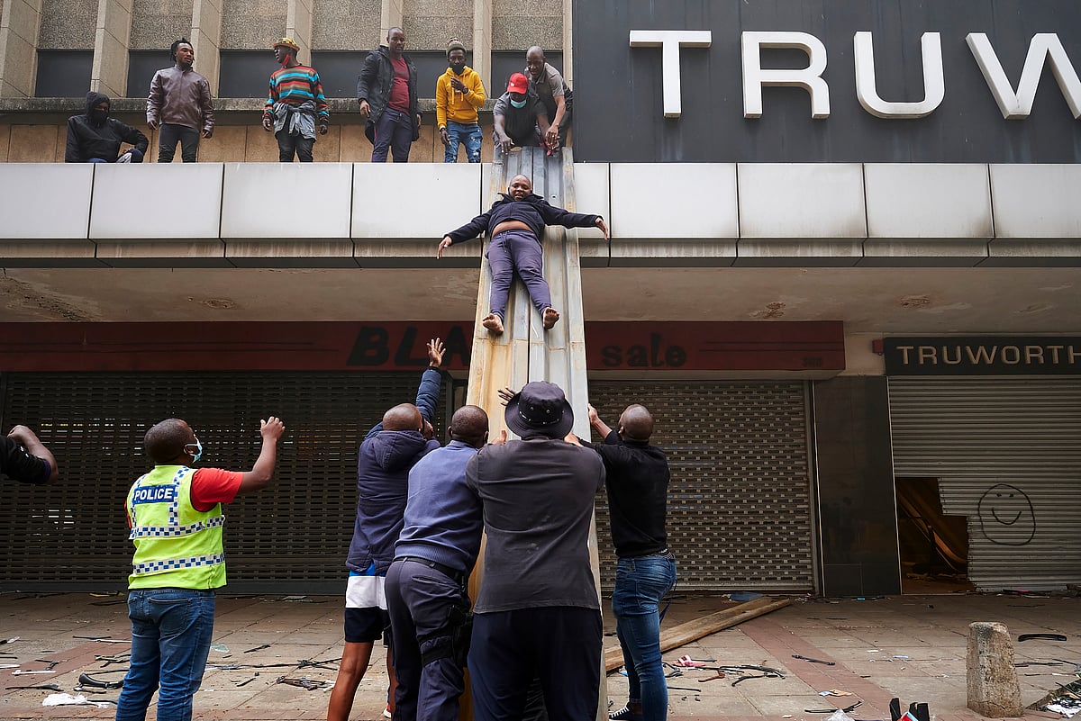 Durban: Children are evacuated from a burning building in downtown Durban, South Africa, Tuesday July 13, 2021, as ongoing violence continues. 