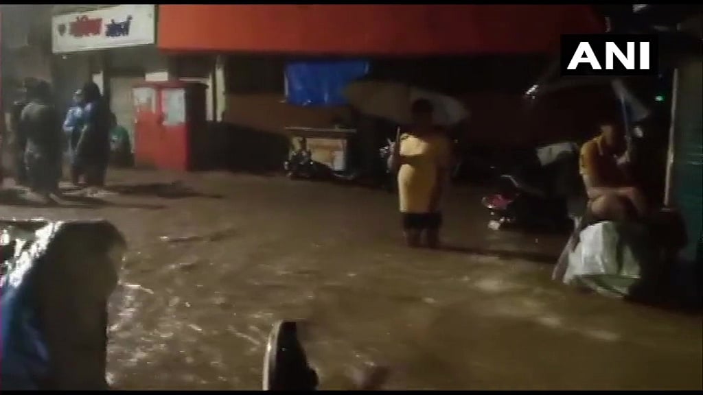 People wadding through waterlogged streets in Kandivali