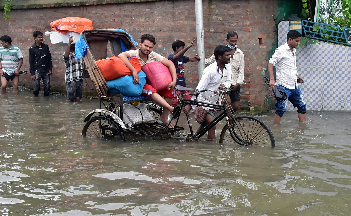West Bengal, July 30 (ANI): People commute through waterlogged road after heavy rainfall, in Kolkata on Friday.