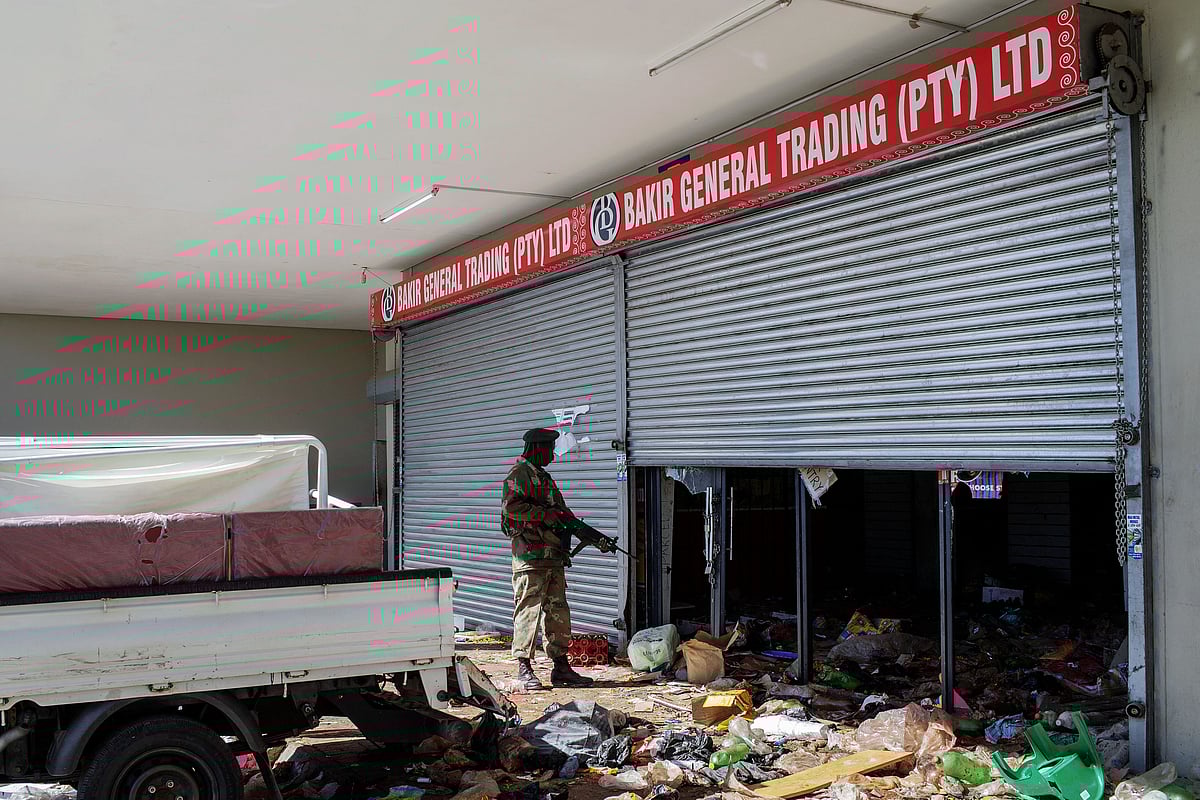 A South Africa National Defence Force (SANDF) soldier stands in front of a looted shop in Soweto on July 13, 2020.