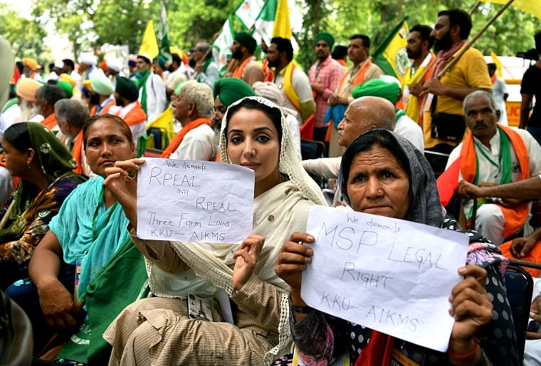 Actress Sonia Mann along with farmers hold placards at Kisan Sansad during a protest against the three farm laws at Jantar Mantar, in New Delhi on Thursday.