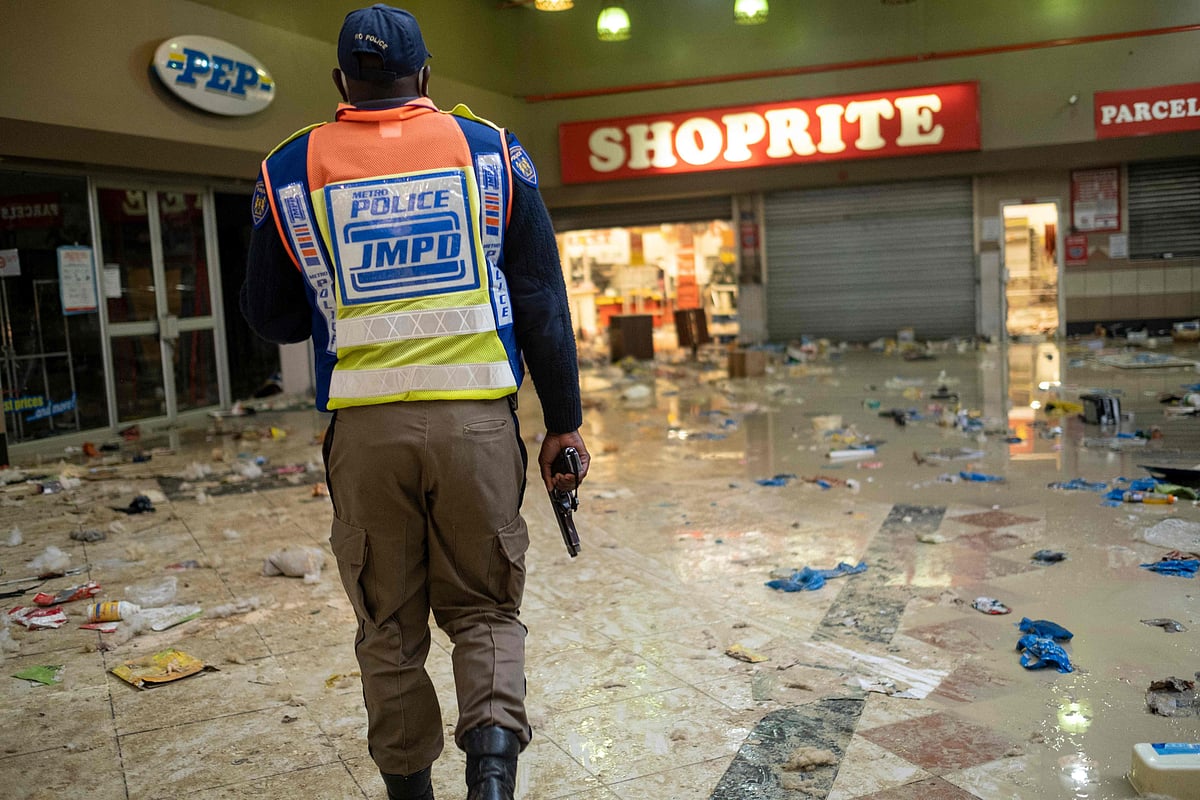 Johannesburg Metro Police Department (JMPD) officer carries his firearm while searching for looters at the Bara Mall in Soweto on the outskirts of Johannesburg on July 13, 2021