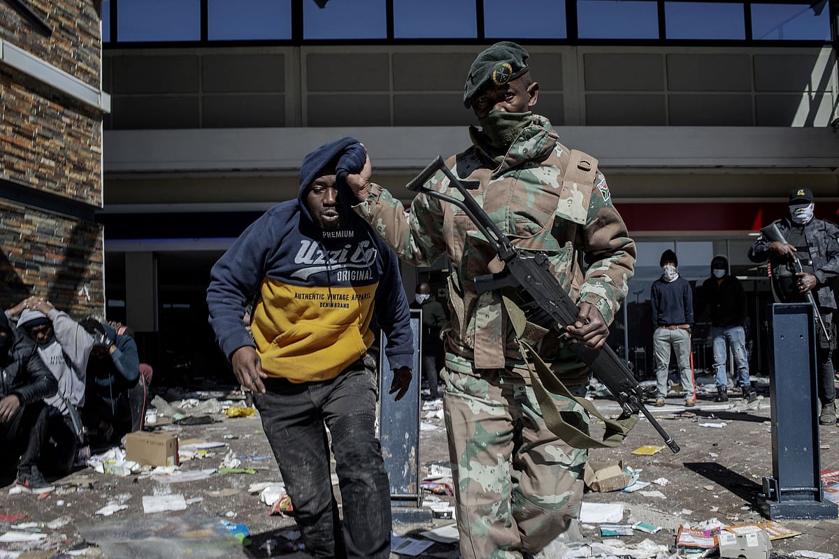 A South Africa National Defence Force (SANDF) soldier detains a suspected looter at Jabulani Mall in Soweto on July 13, 2021. 
