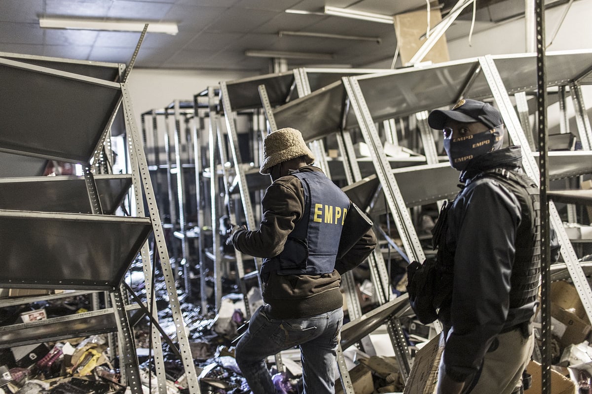 South Africa police officers inspect the damages at a looted mall in Vosloorus, on July 13, 2021.