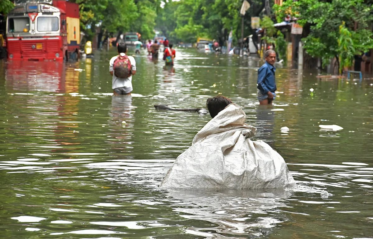 West Bengal, July 30 (ANI): People commute through a waterlogged road after heavy rainfall, in Kolkata on Friday.