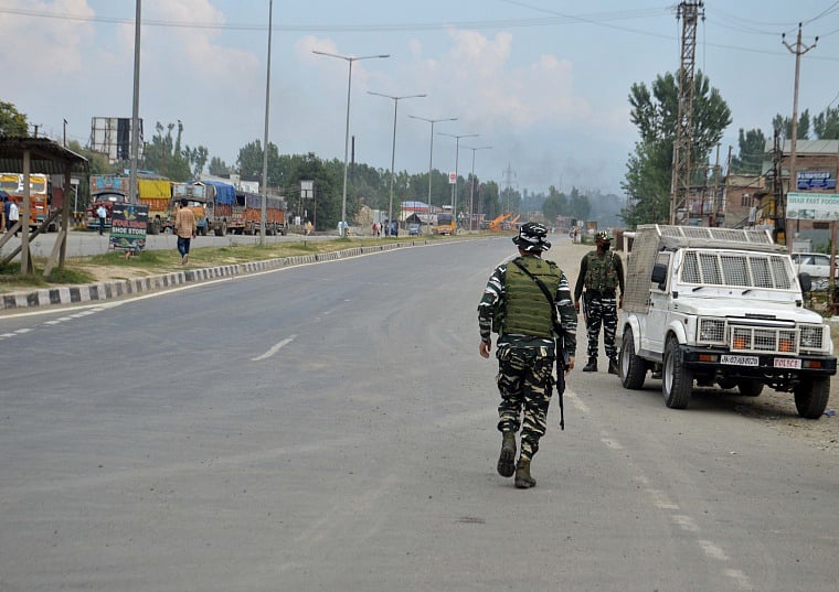 Security personnel guard near the site of an encounter with militants, at Kulgam district of Kashmir on Thursday