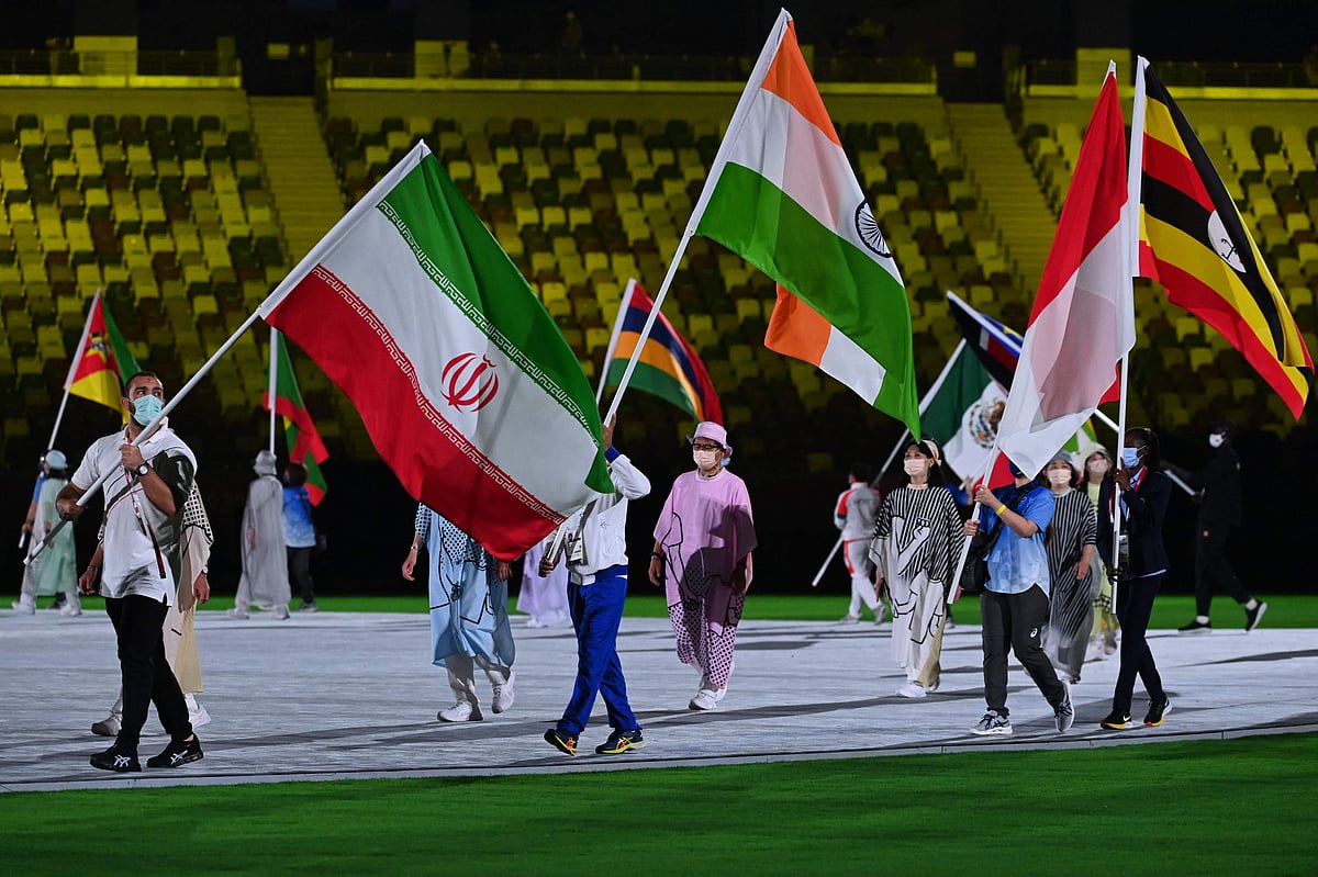 Iran's Amir Hossein Zare (L) and India's Bajrang Bajrang carry their national flags during the closing ceremony of the Tokyo 2020 Olympic Games, at the Olympic Stadium, in Tokyo, Japan, on August 8, 2021.