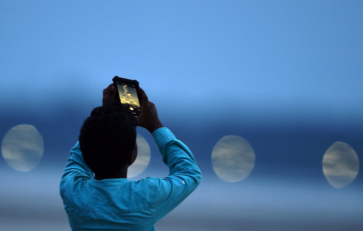 A boy takes picture of ISROs earth observation satellite EOS-03 on-board GSLV-F10 as it blasts off from Sriharikota, on Thursday, Aug. 12, 2021.