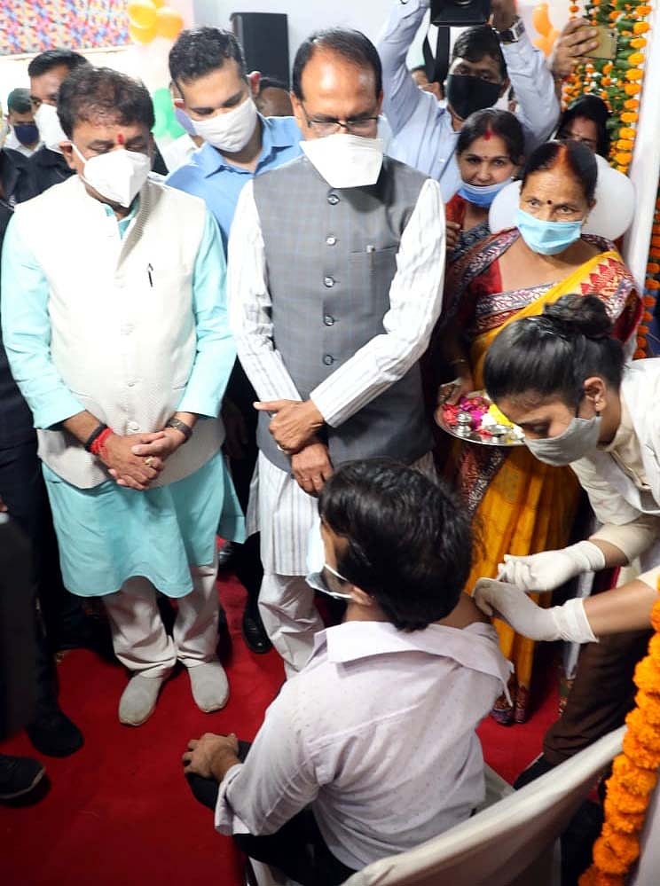 Chief Minister Shivraj Singh Chouhan  and others watche as man receives Covid-19 vaccine in Bhopal on Monday 