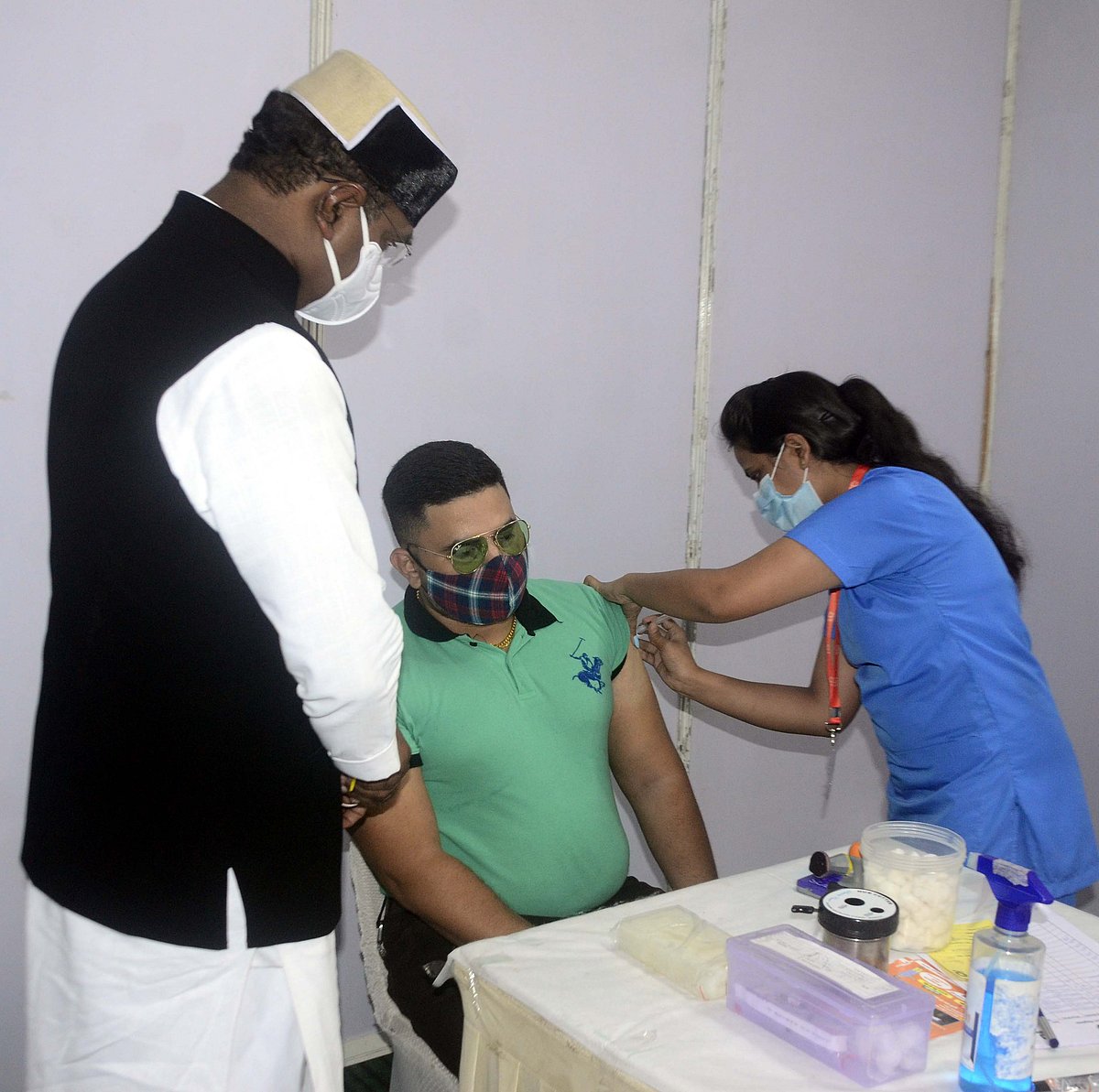 Medical Education Vishwas Sarang  watches as man receives Covid-19 vaccine in Bhopal on Monday 
