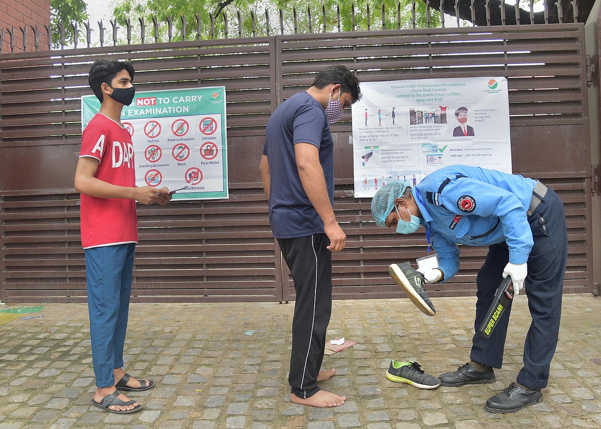 New Delhi: A security guard checks aspirants of medical entrance examination of National Eligibility cum Entrance Test (NEET) outside an examination centre following COVID protocol in New Delhi, Sunday, Sept. 12, 2021.
