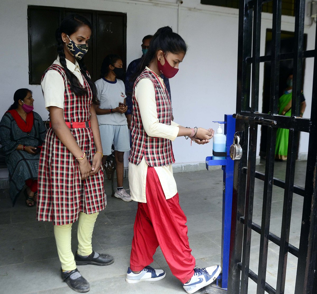 SAFETY FIRST: Girls sanitize their hands before entering into the classrooms to keep infection at bay.