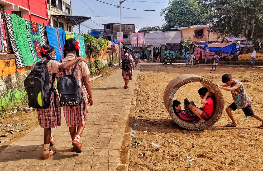 Some students walk towards school while other kids play nearby in Dharavi, Mumbai on Tuesday, October 5, 2021.