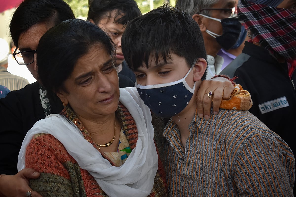 Wife of Makhan Lal Bindroo, a prominent pharmacist, mourns around his body along with other relatives during his funeral at his residence in Srinagar, Kashmir on Wednesday, October 6, 2021.
