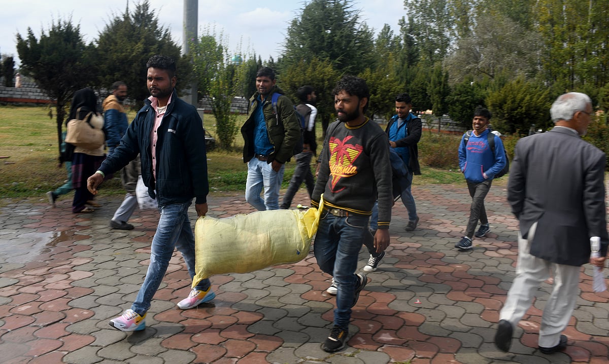 Group of Migrant workers walk towards a railway station in Srinagar to return to their home after fresh of violence against civillians including non locals in the past week across Kashmir