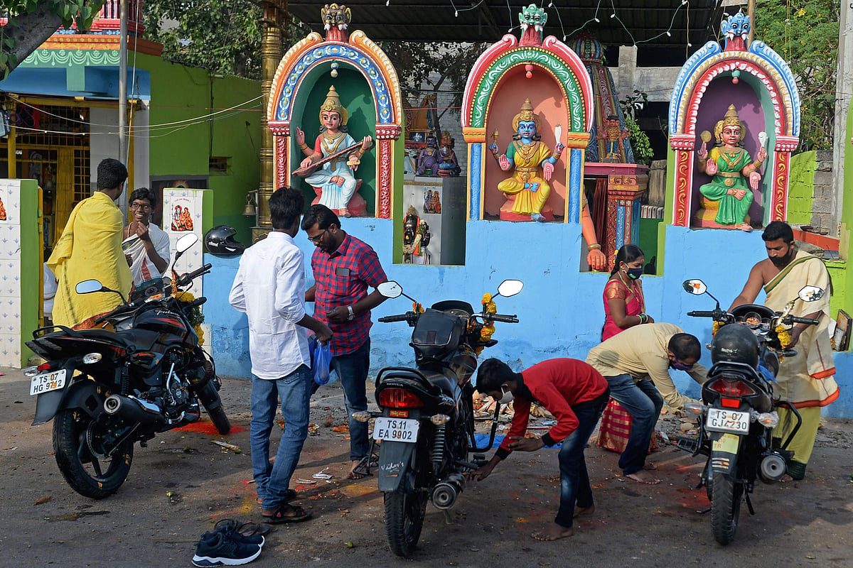 Devotees perform Ayudha Puja ritual on their motorbikes on the occasion of Dussehra-Vijay Dashami festival outside a temple in Hyderabad on October 15, 2021.