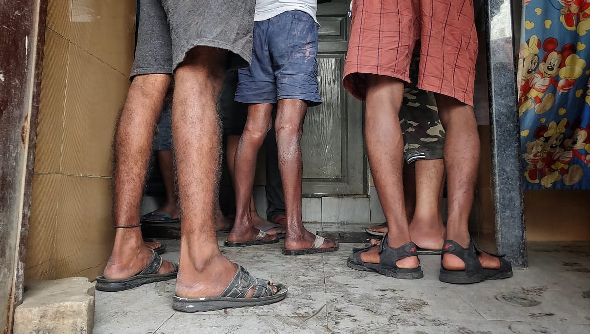 Men wait for their turn at public toilets in Dharavi, Mumbai.