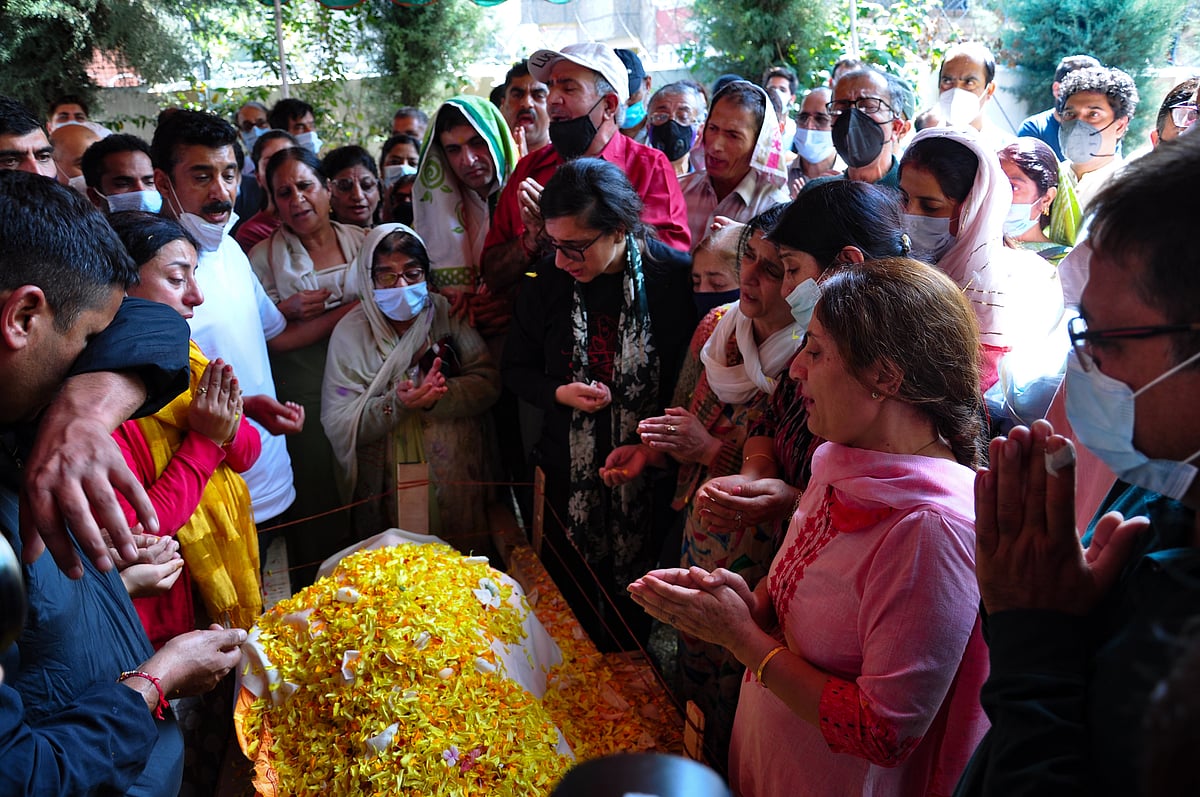 Relatives mourn around the body of prominent pharmacist Makhan Lal Bindroo during his funeral at his residence in Srinagar, Kashmir on Wednesday, October 6, 2021.