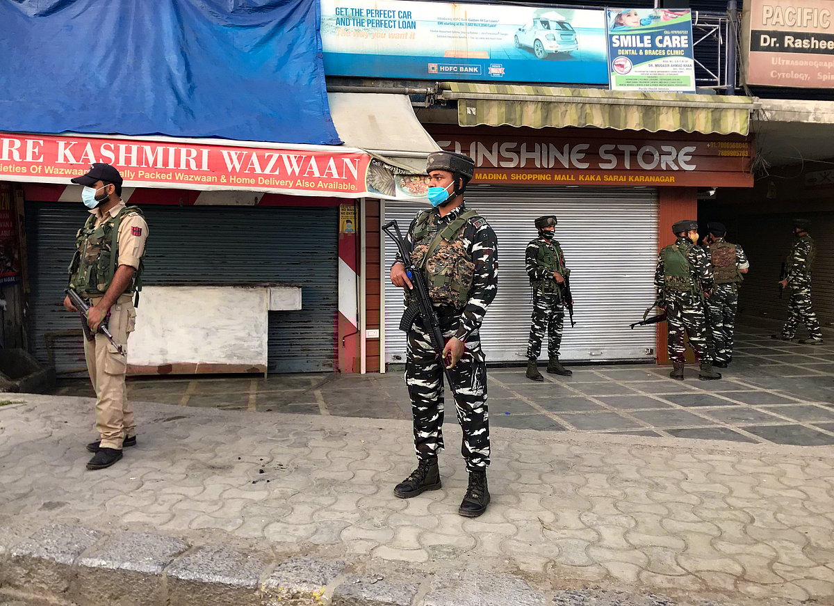 Security personnel stand guard near the site where a man was shot dead by suspected militants in the Karanagar area of downtown Srinagar on October 2, 2021.