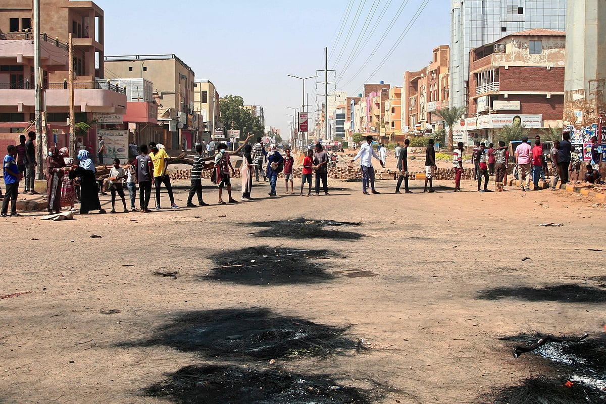 Sudanese demonstrators set up brick roadblocks on a street in the capital Khartoum, on October 26, 2021, as they protest a military coup that overthrew the transition to civilian rule. 