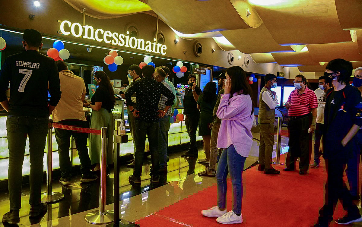 People wait in line to buy snacks at a cinema theatre in Mumbai