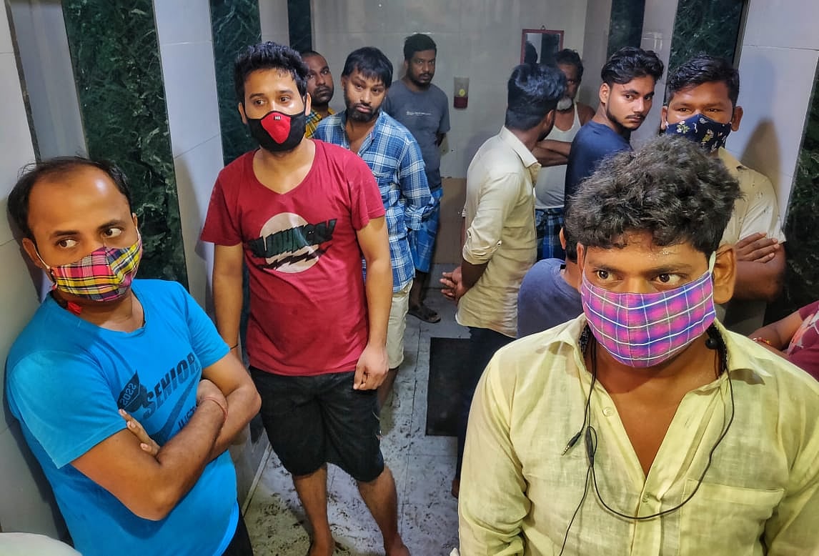 Men wait for their turn at public toilets while following COVID-19 protocols in Dharavi, Mumbai.