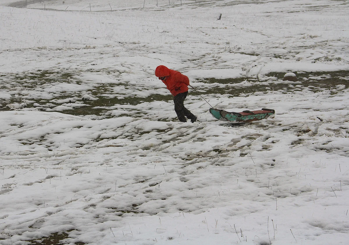 A man seen pulling his toboggan (sledge) through snow during season's first snowfall, in World famous Ski resort Gulmarg, Kashmir, On October 23, 2021