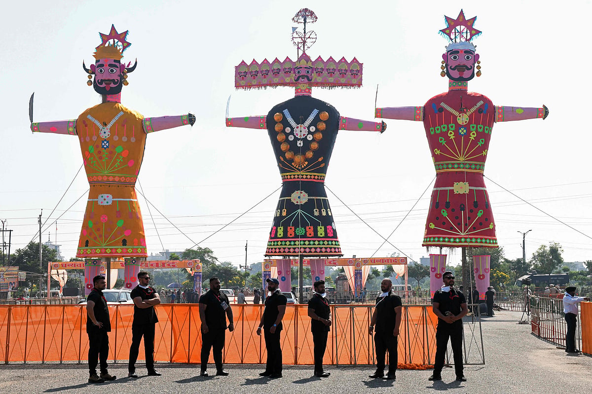 Security personnel stand guard near the effigies of demon king Ravana, his son Meghnath and brother Kumbhkaran before they are set alight to mark the Hindu festival of Dussehra in Amritsar on October 15, 2021.