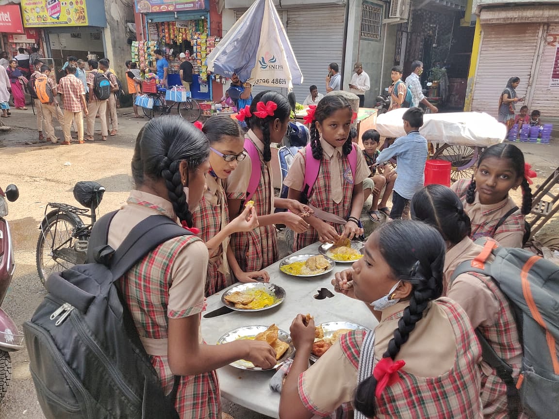 A group of young girls in Dharavi have breakfast before heading to school.