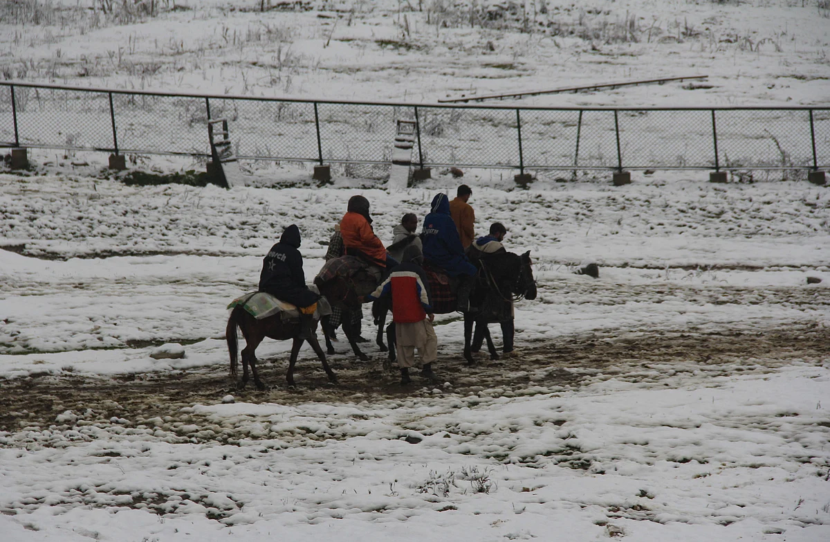 Tourists rides on horses during the season's first snowfall, in World famous Ski resort Gulmarg, Kashmir, On October 23, 2021