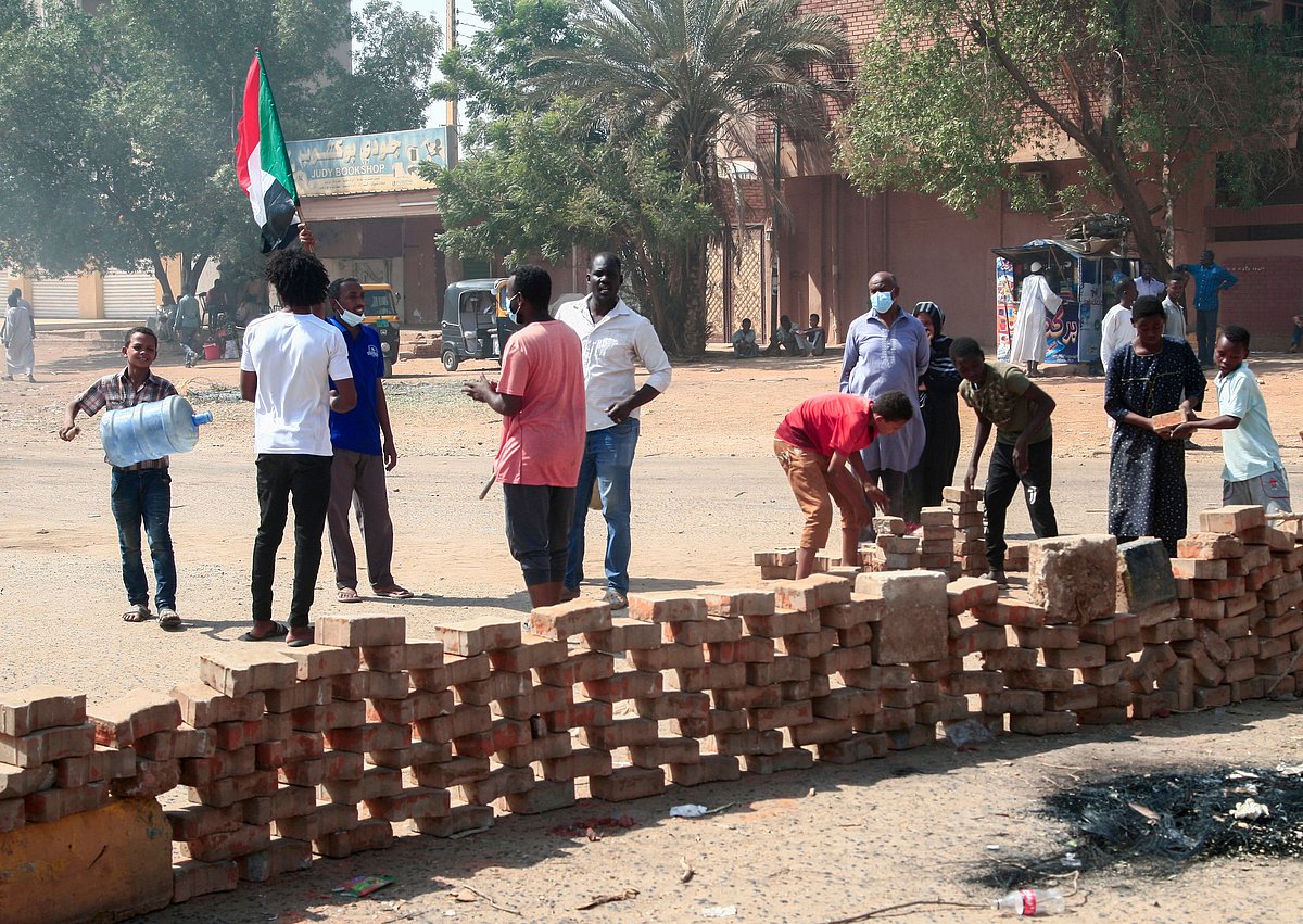 Sudanese demonstrators set up brick roadblocks on a street in the capital Khartoum, on October 26, 2021, as they protest a military coup that overthrew the transition to civilian rule. 