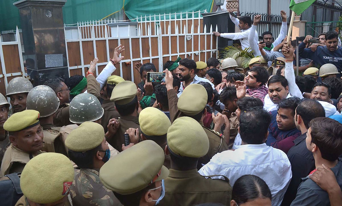 Police personnel look on as farmers protest outside MLA Pankaj Singhs office, in Noida,