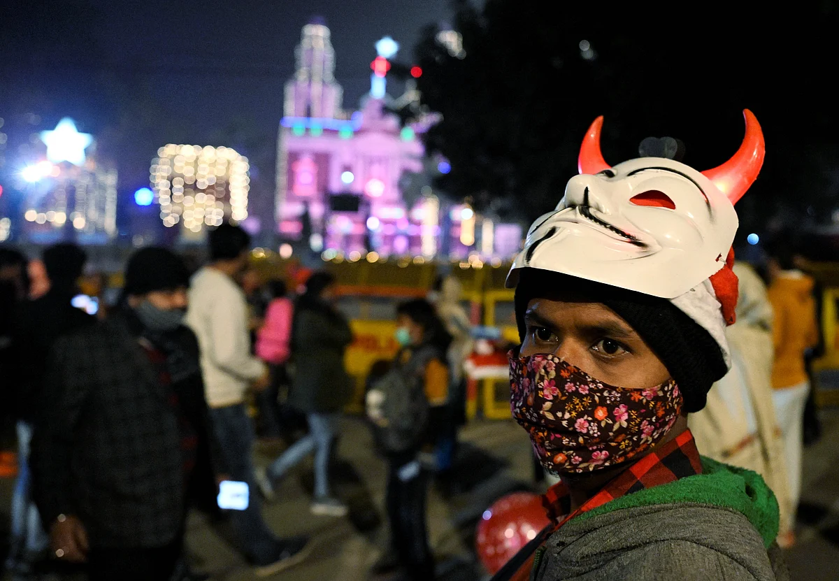 New Delhi: A boy sells Christmas items near the main gate of Sacred Heart Cathedral Church illuminated on the eve of Christmas, in New Delhi, Friday, Dec. 24, 2021