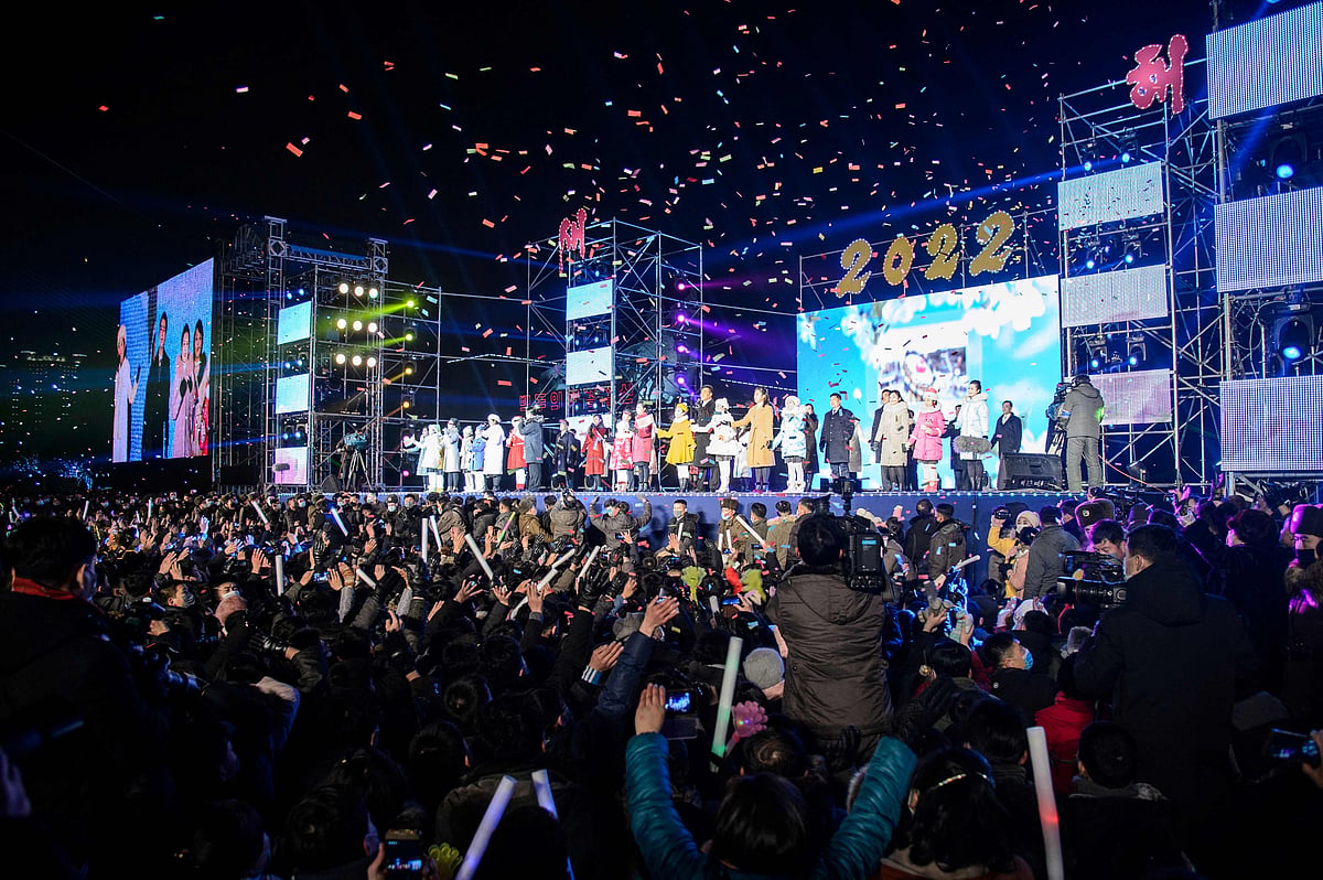 People watch as performers take part in a new year performance on Kim Il Sung Square in Pyongyang late on December 31, 2021.