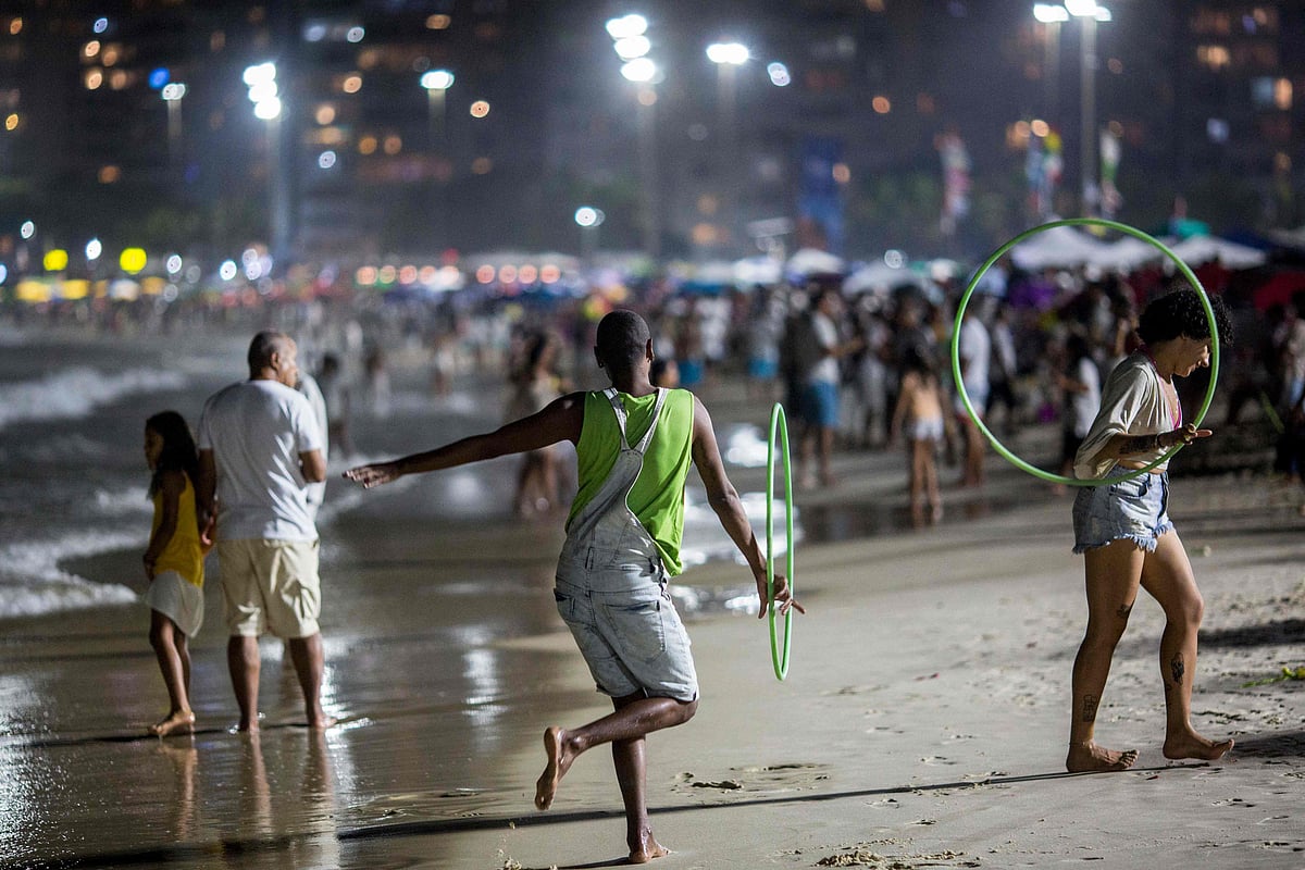A man dances near the water on New Years Eve at Copacabana beach in Rio de Janeiro, Brazil on December 31, 2021.