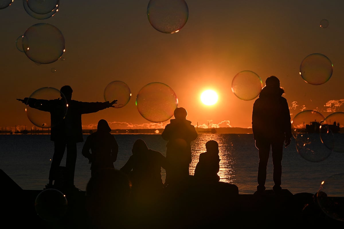 People gather at a seaside park to watch the sunrise on New Years Day in Tokyo on January 1, 2022. 