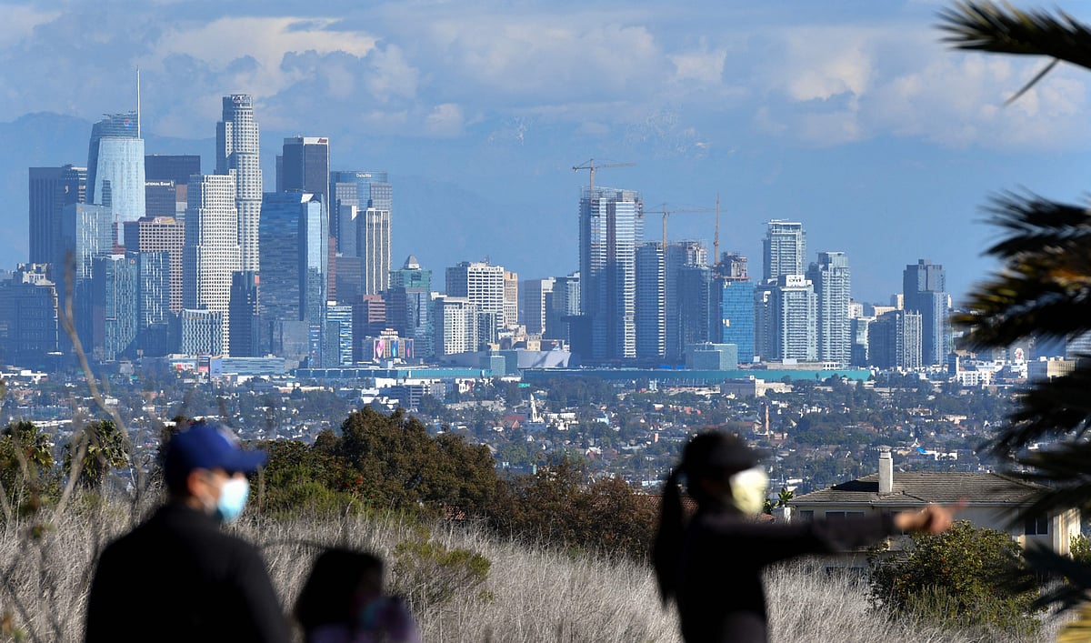 People enjoy the sunny afternoon on New Years Eve in a Los Angeles park with a view of the downtown skyline, December 31, 2021. 