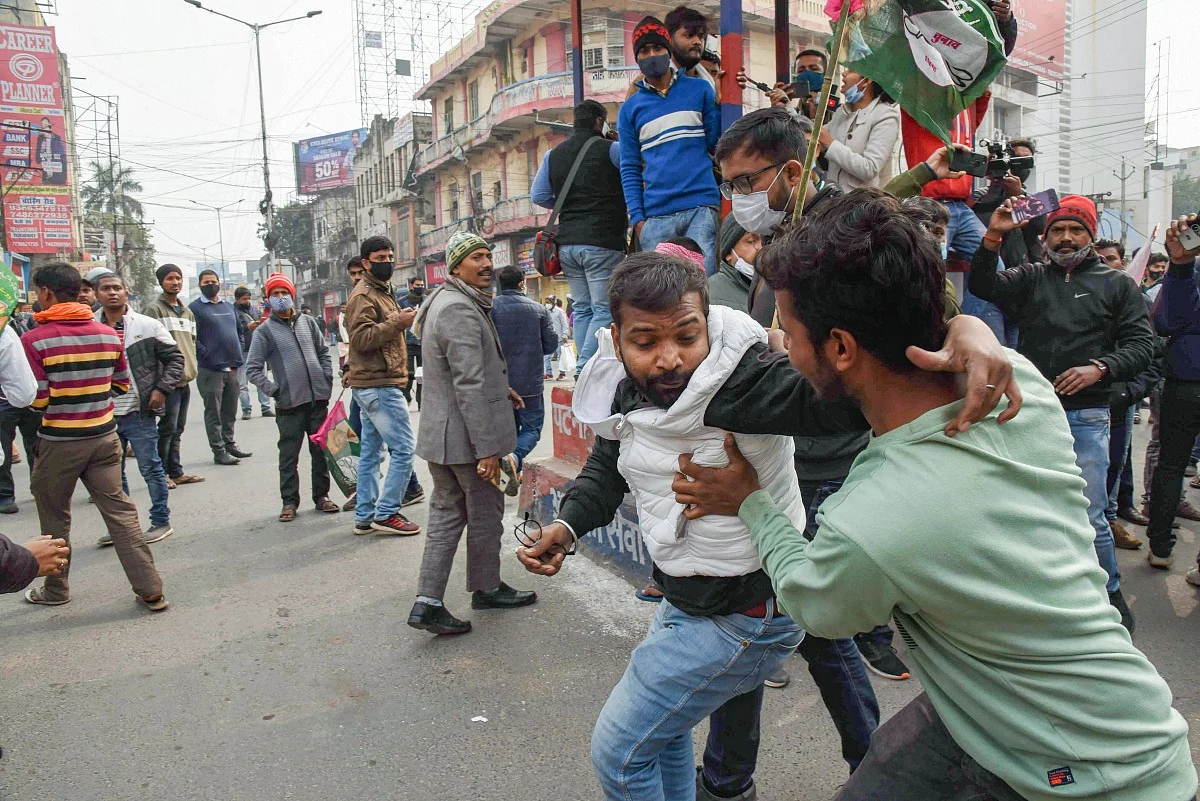 Security personnel detain a protester during the Bihar bandh protest over alleged erroneous results of Railway Recruitment Boards Non-Technical Popular Categories (RRB NTPC) exam, in Patna, Friday, Jan. 28, 2022.