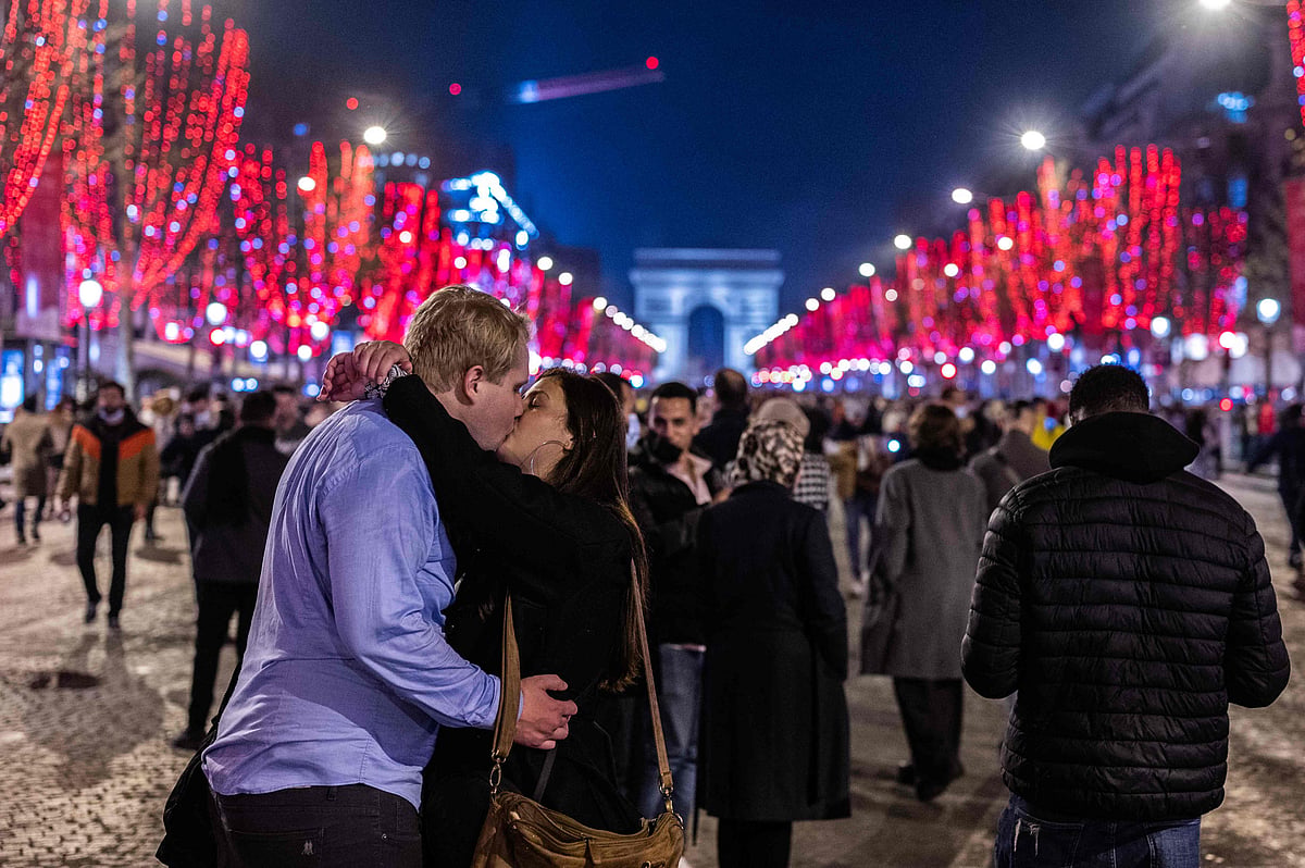 A couple kisses on the Champs-Elysees Avenue in Paris early on New Years day, January 1, 2022.