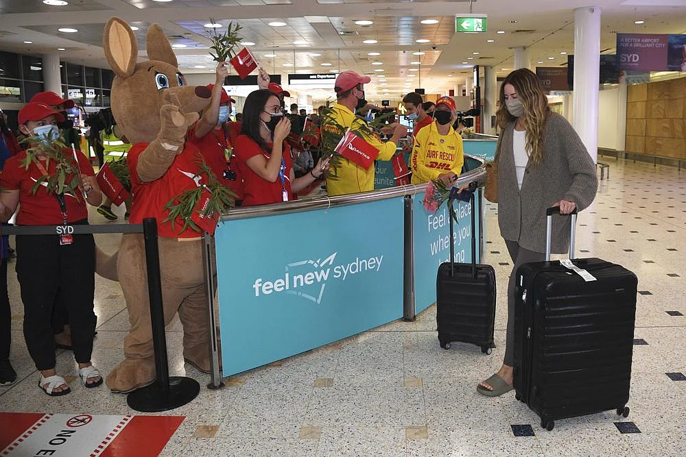 Passengers are welcomed as they arrive at Sydney International Airport in Sydney, on Monday | AP