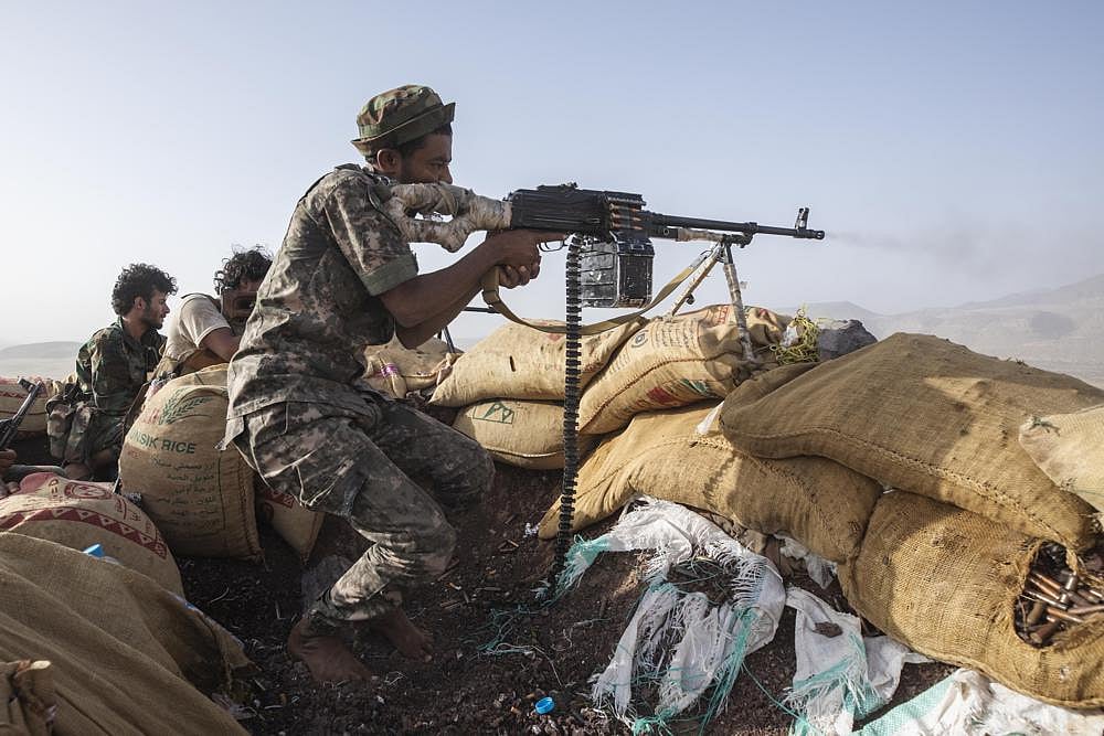 A Yemeni fighter backed by the Saudi-led coalition fires his weapon during clashes with Houthi rebels on the Kassara frontline near Marib, Yemen | AP