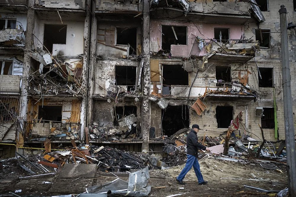 A man walks past a building damaged following a rocket attack the city of Kyiv, Ukraine, on Friday | AP