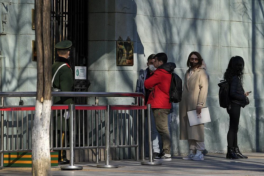 A Chinese paramilitary policeman stands watch as people wait to enter the Russian Embassy in Beijing, on Thursday | AP