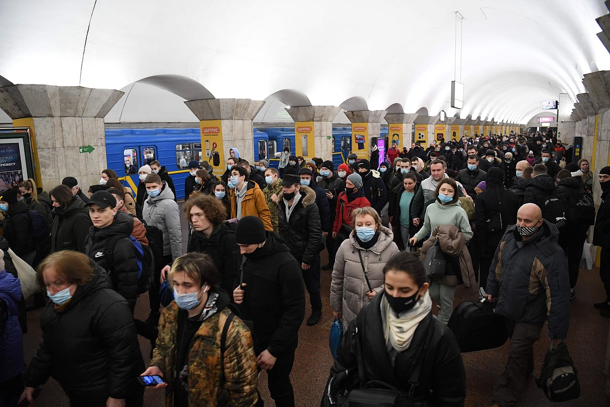 People, some carrying bags and suitcases, walk at a metro station in Kyiv early on February 24, 2022.