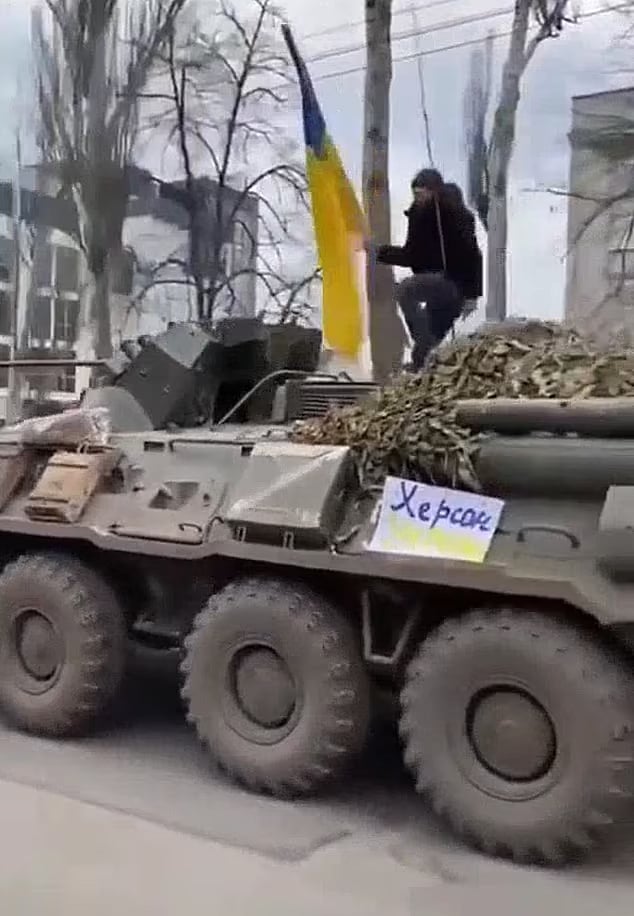 Watch Video: Ukrainian man climbs on top of Russian tank to wave national flag